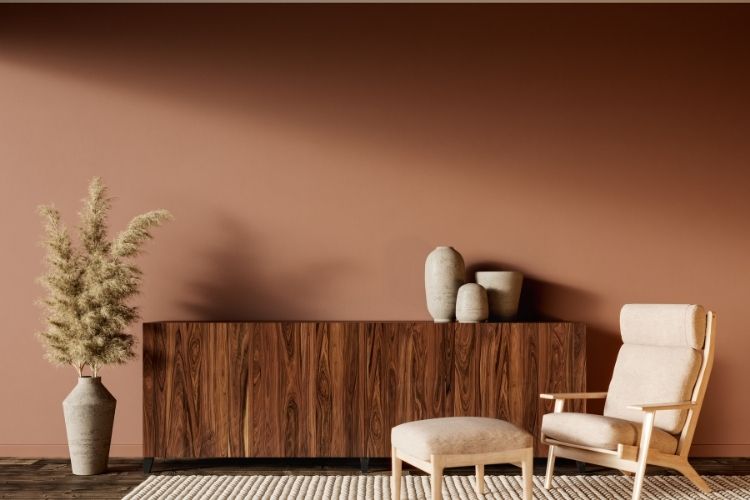 Meleg barna falszínnel festett fal természetes fa bútorokkal és letisztult berendezéssel